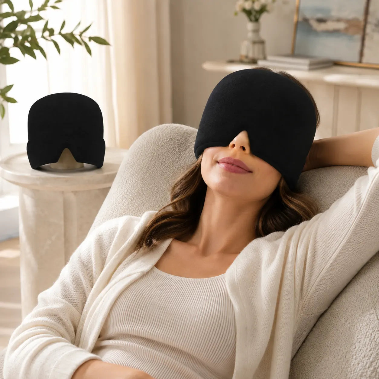 Woman relaxing on a sofa wearing a black gel ice pack head wrap over her eyes