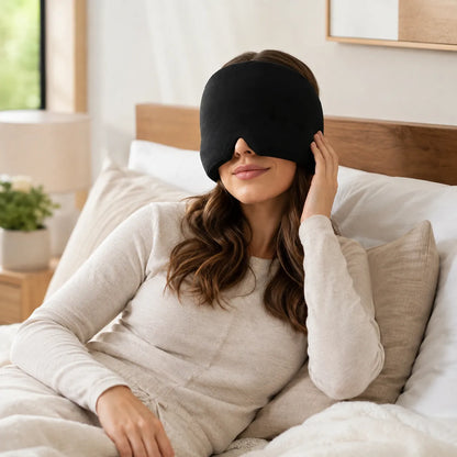 Woman resting in bed wearing a black gel ice pack head wrap for headache relief